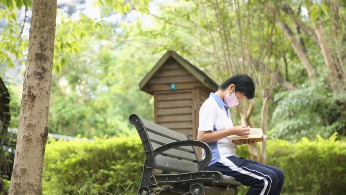 疫情戴口罩学生校园里看书