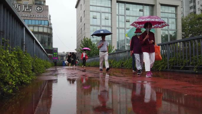 4K下雨天市民打伞在天桥上行走