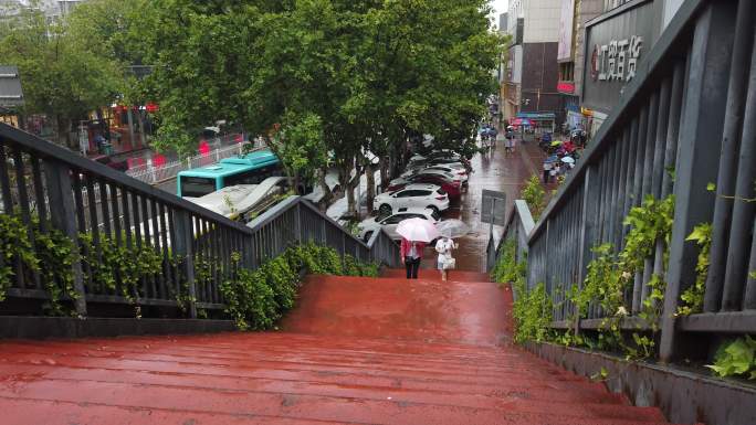 4K下雨天市民打伞在天桥上行走