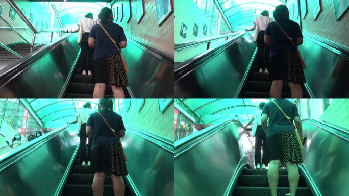 夏天搭乘广州地铁的市民乘手扶电梯出站