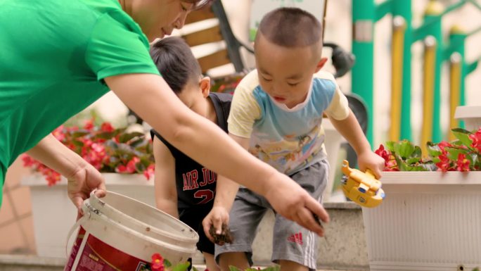 奶奶带着孙子给花施肥填土