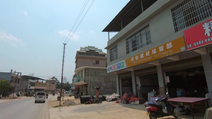 车窗外云南勐海近郊老公路两边的建筑