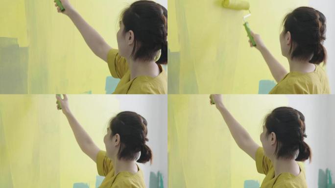 女士刷漆刷漆墙上滚漆装修房屋粉刷