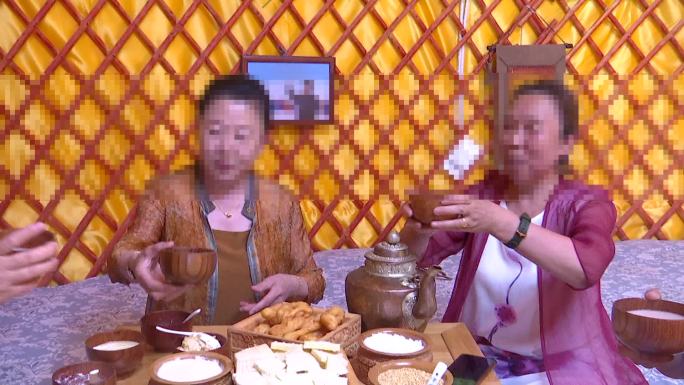 游客在草原蒙古包里吃蒙餐喝奶茶拍照