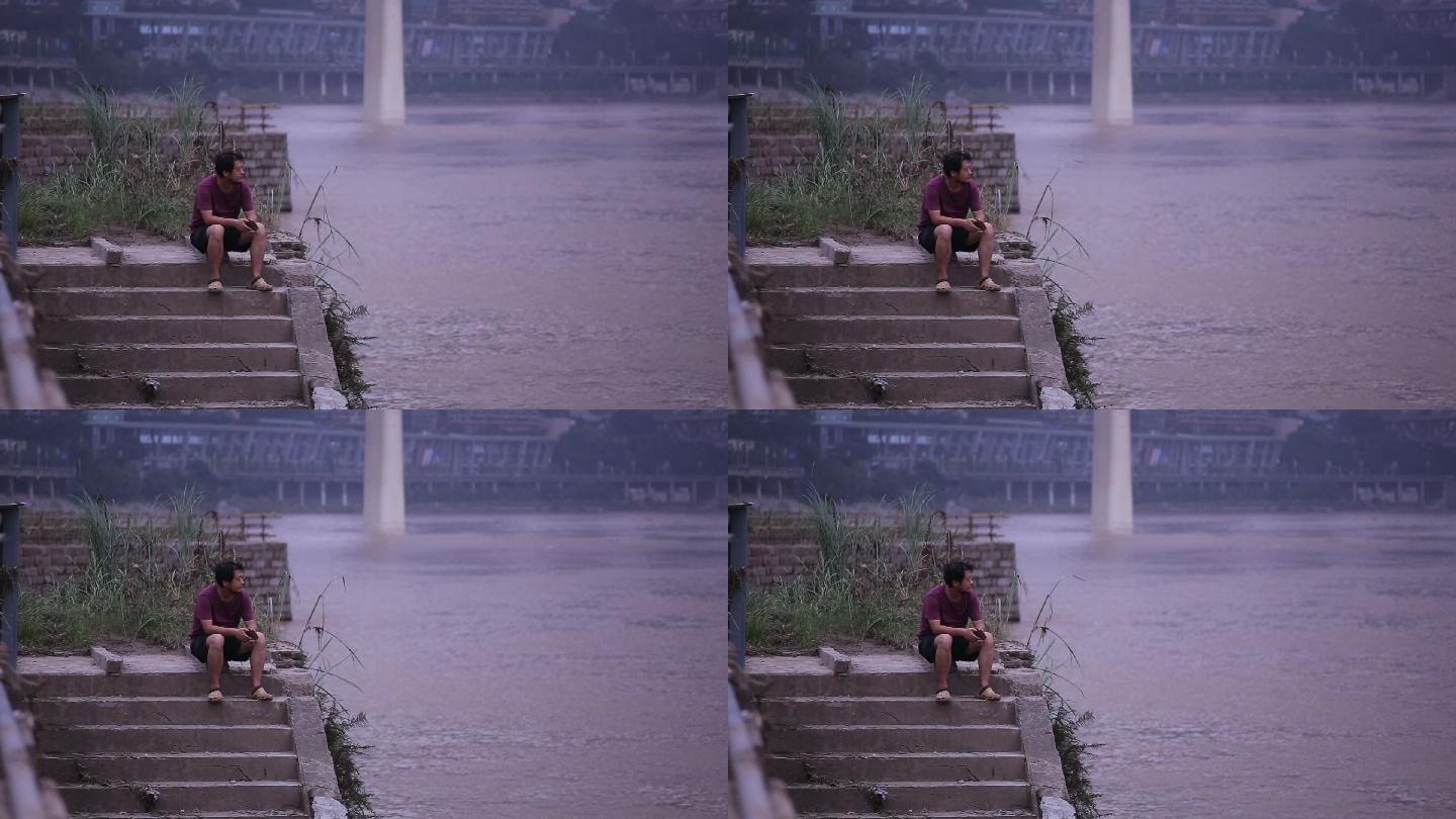 坐在嘉陵江边看着洪水发愁的男子