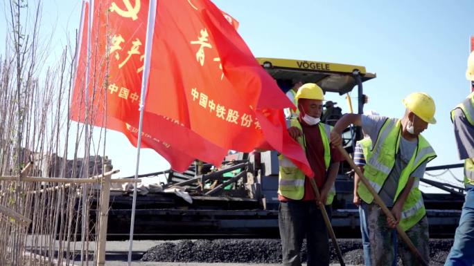 中国中铁旗帜迎风飘扬压路机施工