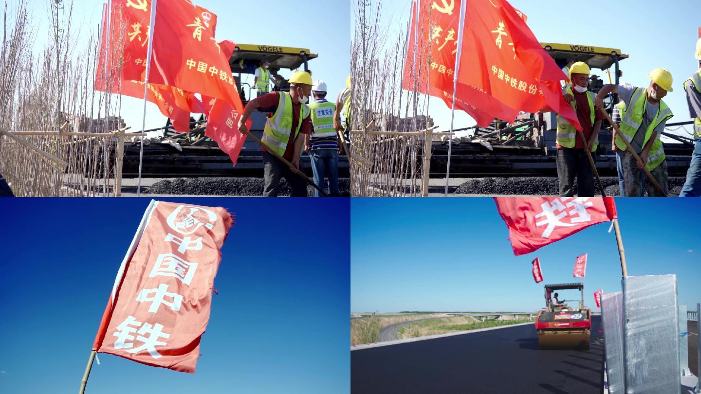 中国中铁旗帜迎风飘扬压路机施工
