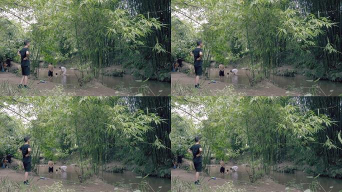 在森林里的竹林小溪沟里人们在戏水冲凉
