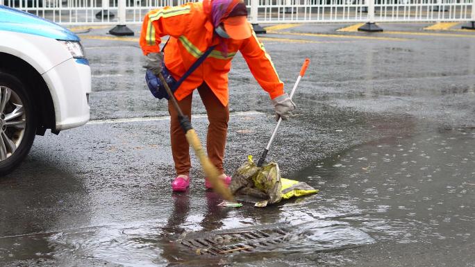 下雨天环卫清洁工人打扫街道