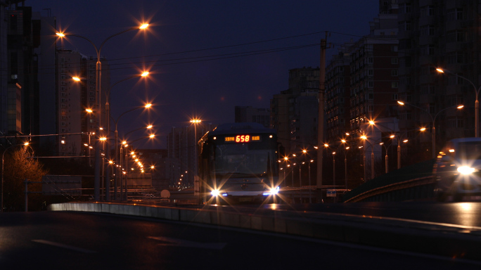 路灯傍晚，城市公交车，行驶车流，北京街道