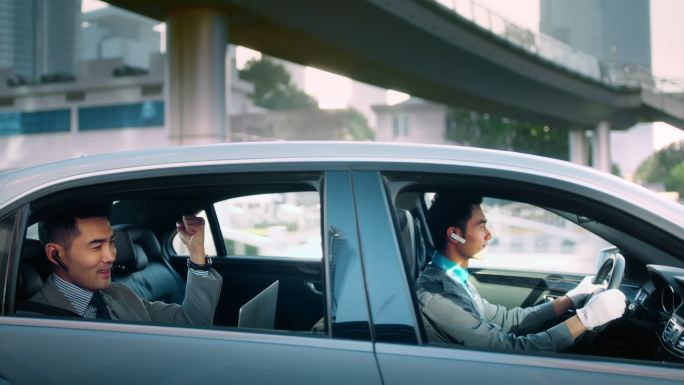商务男车后座谈成业务握拳庆祝开