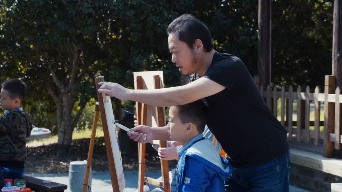 公园老师教孩子画画户外画画柳树下