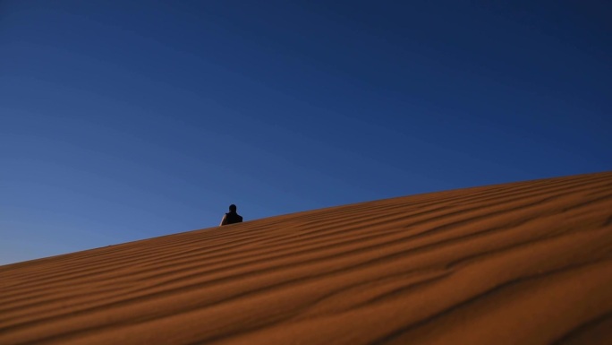 沙漠里走远的和走近的男人