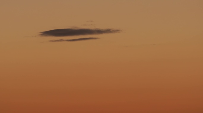 4K黎明橙色天空上的一朵云