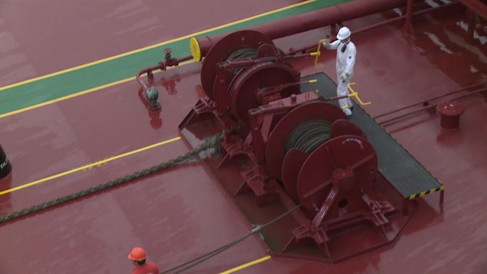 拖船拖万吨油轮驶离开码头，甲板海员作业
