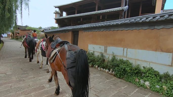 云南大理沙溪古镇骑马的游客牵马的人