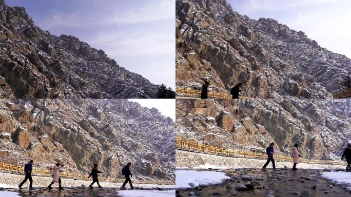 4K贺兰山冬季雪山下小溪中涉水的游客