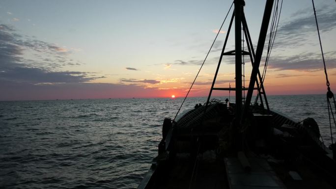 海上日出，渔船航行