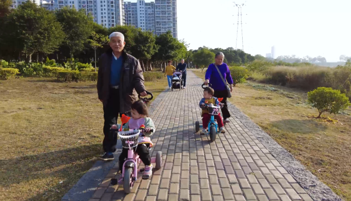 公园里推着婴儿车的老人和孩子