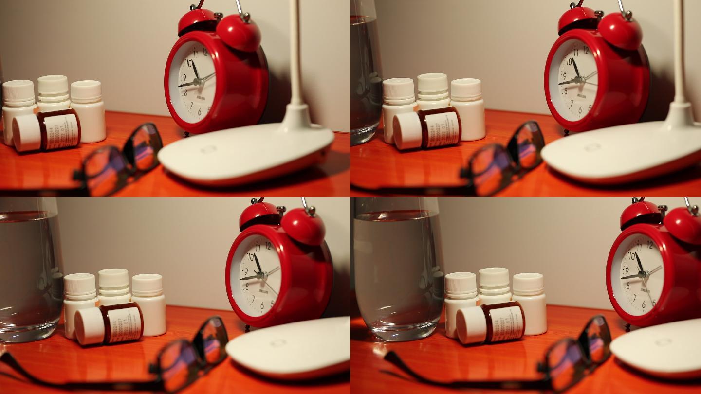 放在桌子上的水杯药瓶闹钟和眼镜