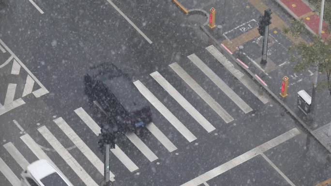 4K下大雪街道上的车辆行人过斑马线雪花