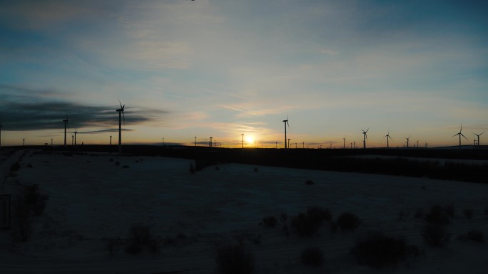 航拍雪地夕阳风力发电机塞罕坝