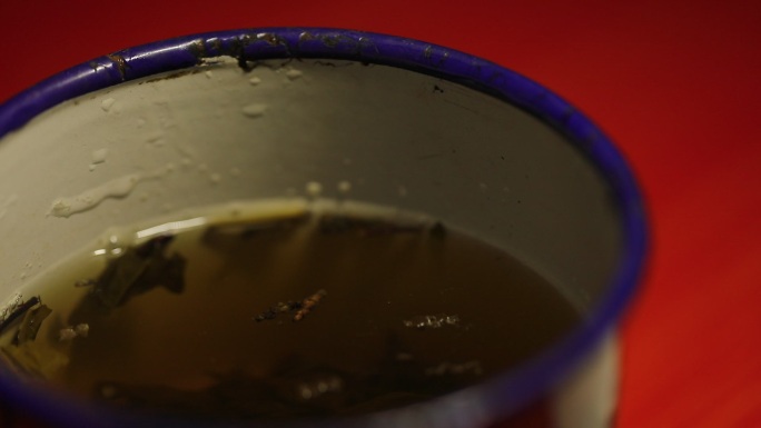 装茶水的旧搪瓷茶缸局部特写