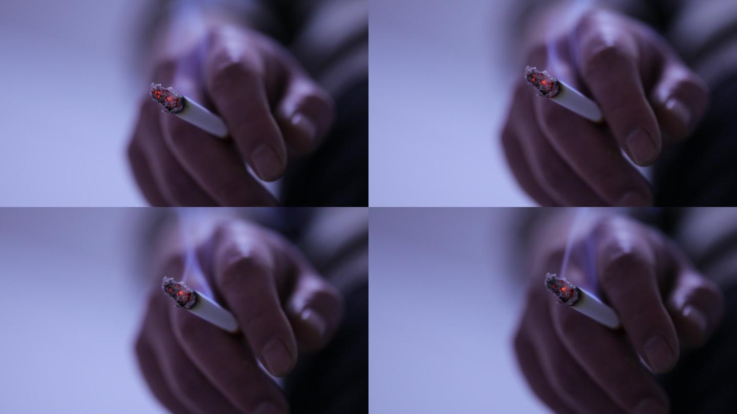 夹在手指间点燃的香烟特写