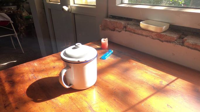 旧房子桌子上的旧搪瓷茶缸