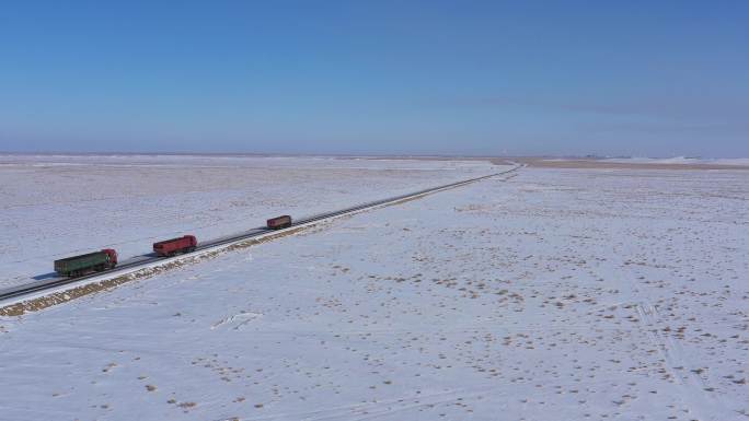 航拍雪后大漠戈壁公路货车