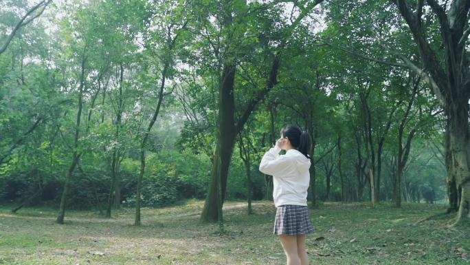 【100帧】美女在树林戴耳机唯美视频素材