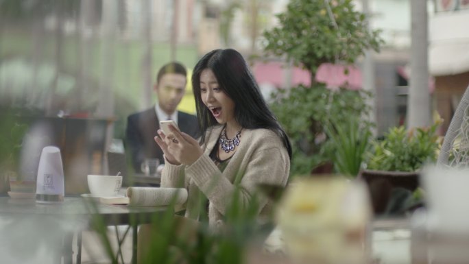 美女咖啡厅玩手机手机购物发现优惠信息
