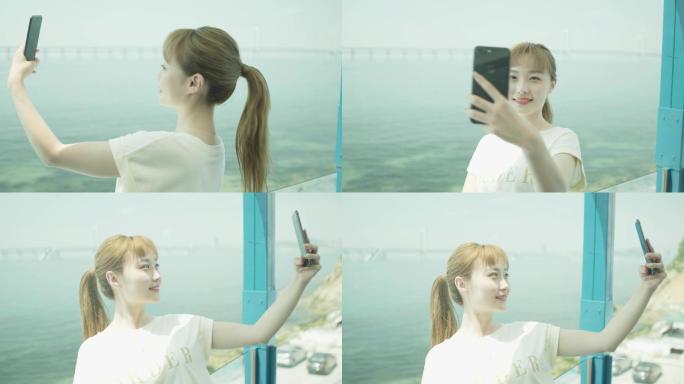 时尚活泼的女士在海边使用智能手机拍照