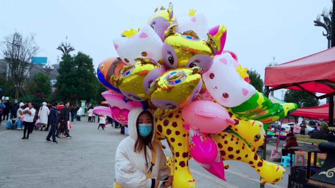 戴口罩卖气球的小女孩公园游乐场游玩小朋友