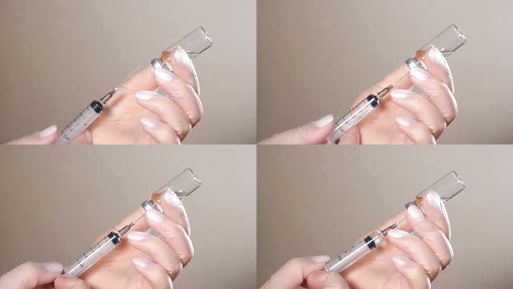 护士用注射器从疫苗瓶中抽取