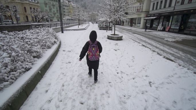 行人在欧洲的小镇雪中行走走路