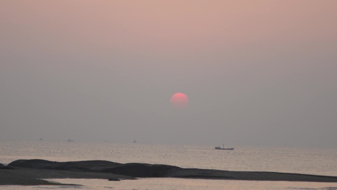 海上日出渔船在海上驶过