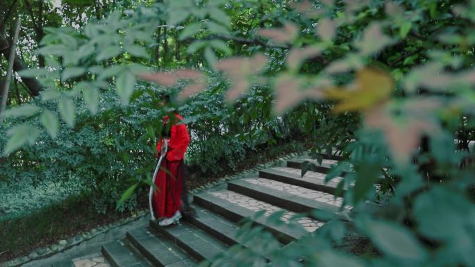 红裙汉服女子行走在林荫小径