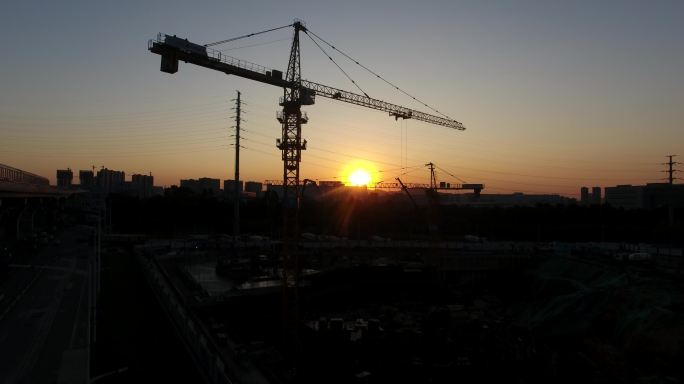 夕阳斜射下建筑工地塔吊剪影