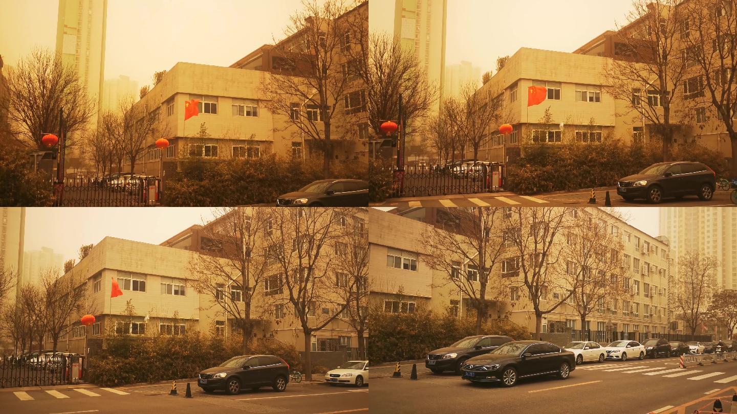 北京罕见沙尘暴街景汽车行驶小区门口红旗飘