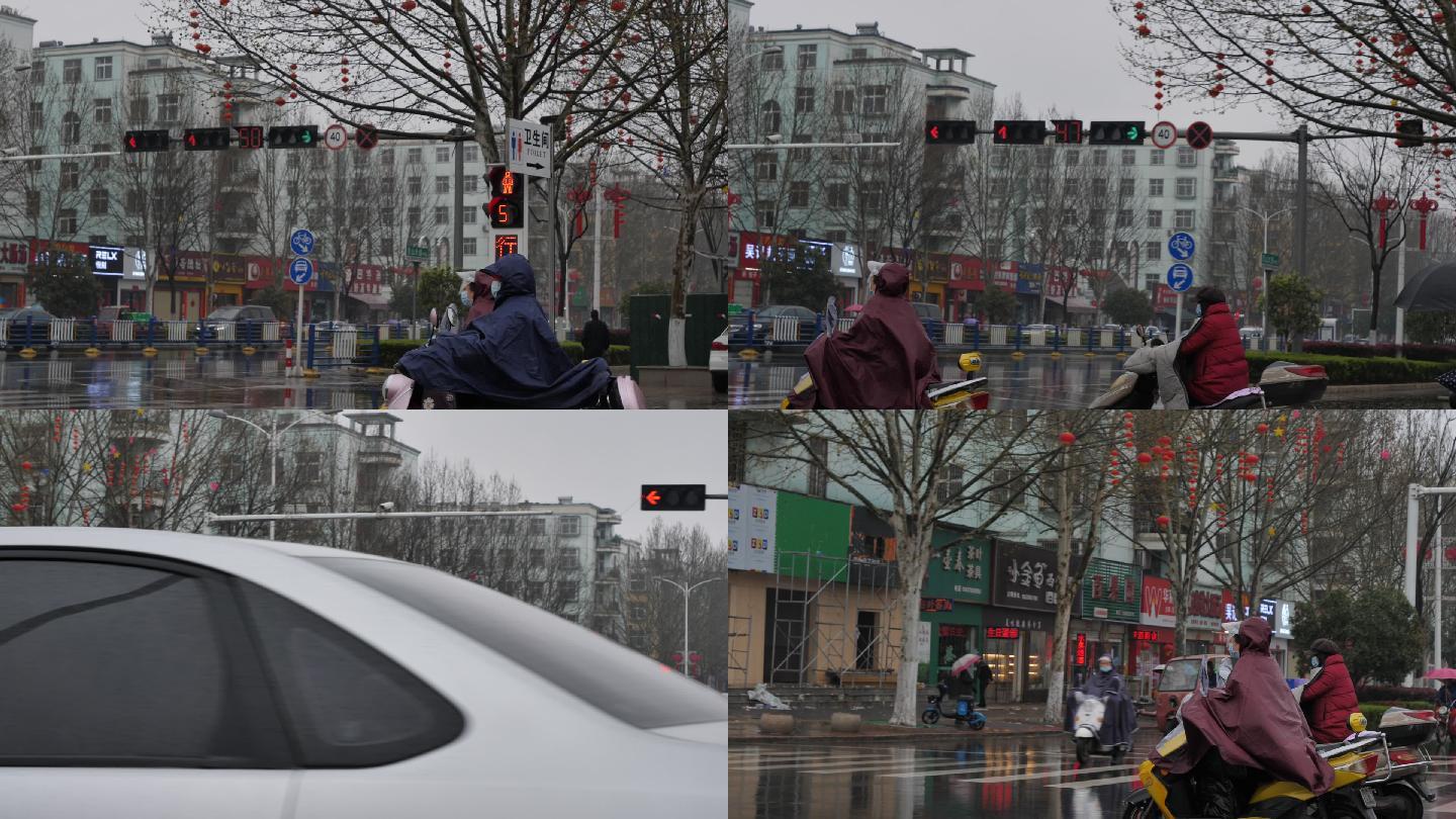 下雨天行人穿雨衣骑电动车红绿灯