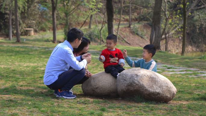 4K春天阳光下的草地上一家人在开心游戏