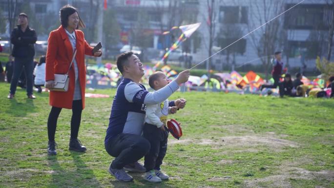 放热气球，放风筝，公园草地欢快的人们。