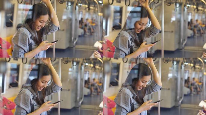 在地铁里用智能手机的年轻女子