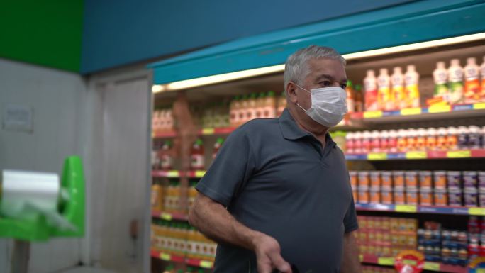 老人戴着一次性医用口罩在超市购物