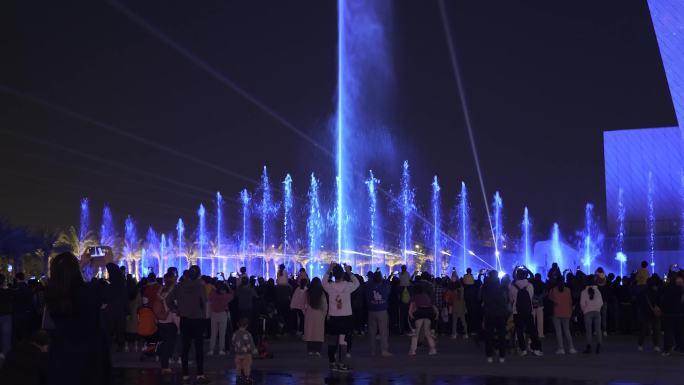 人群观看大型喷泉灯光秀表演