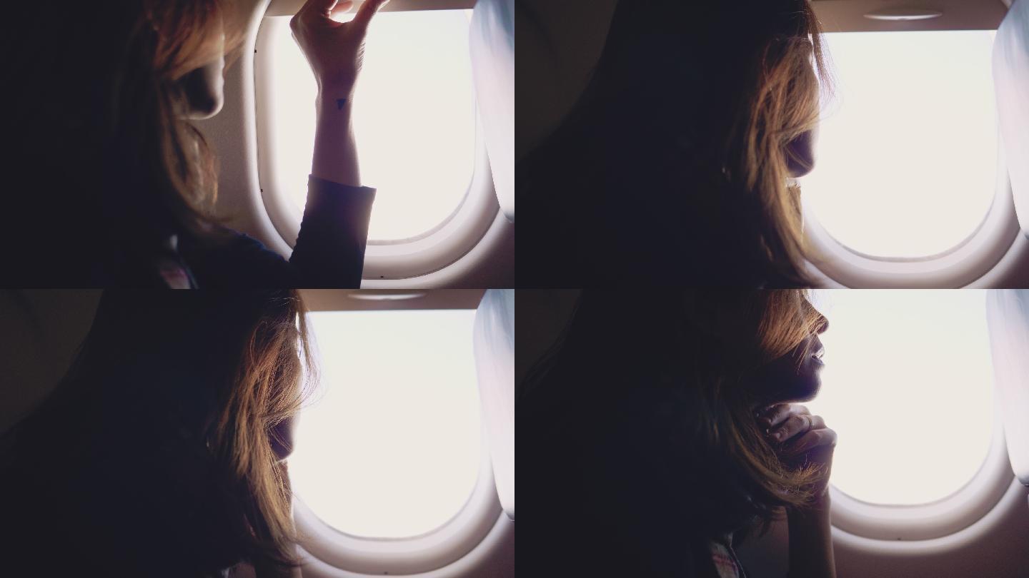 亚洲女游客在飞机上打开窗户