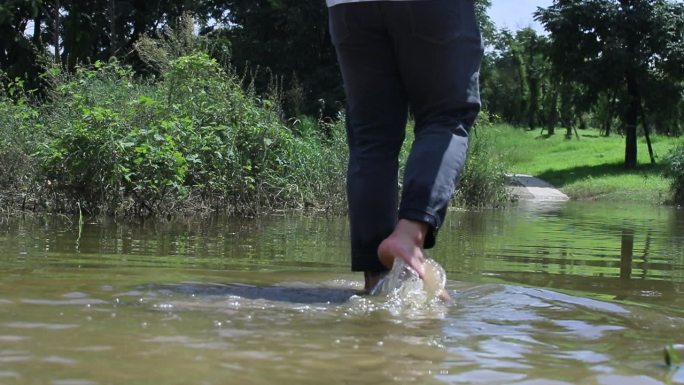 男子淌水走过水洼