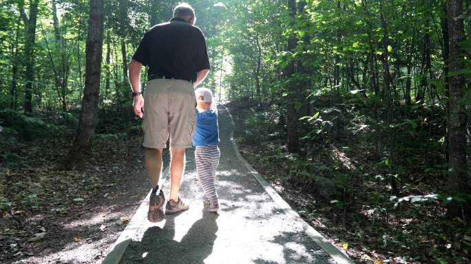 爷爷和孙子在森林小道散步