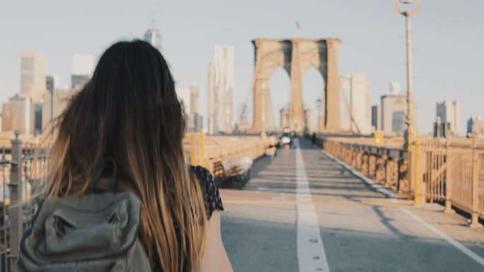 年轻女子在纽约布鲁克林大桥上行走